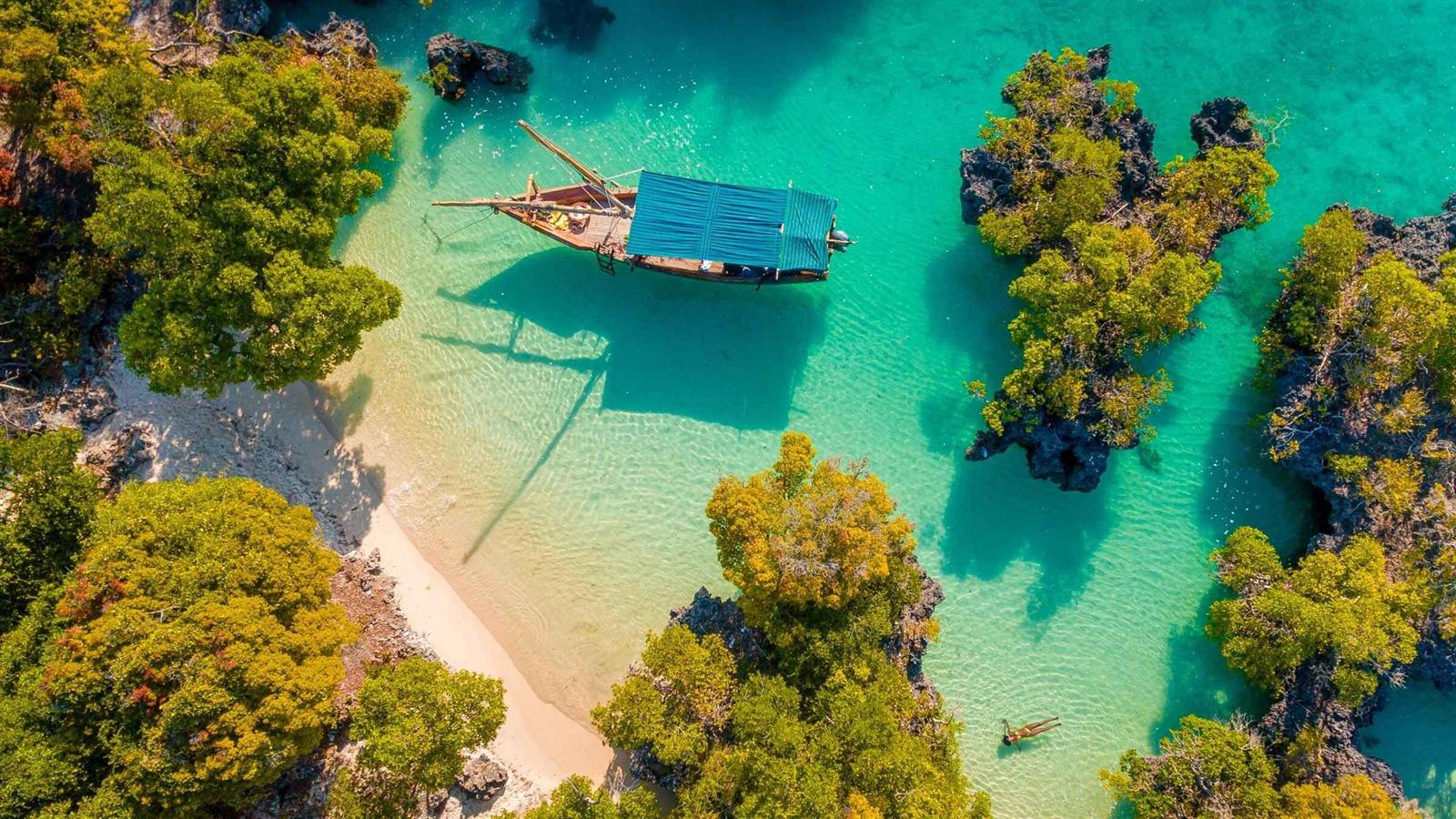 Aerial view of a dhow anchored over turquoise water in Zanzibar